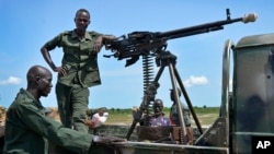 Les soldats du gouvernement montent la garde près de leur véhicule sur les lignes de front dans la ville de Kuek, dans le nord de l'état du Haut-Nil, au Sud-Soudan.