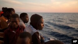 Des migrants subsahariens se tiennent sur le pont du bateau de sauvetage Golfo Azzurro à leur arrivée au port de Pozzallo, en Italie, le 17 juin 2017.