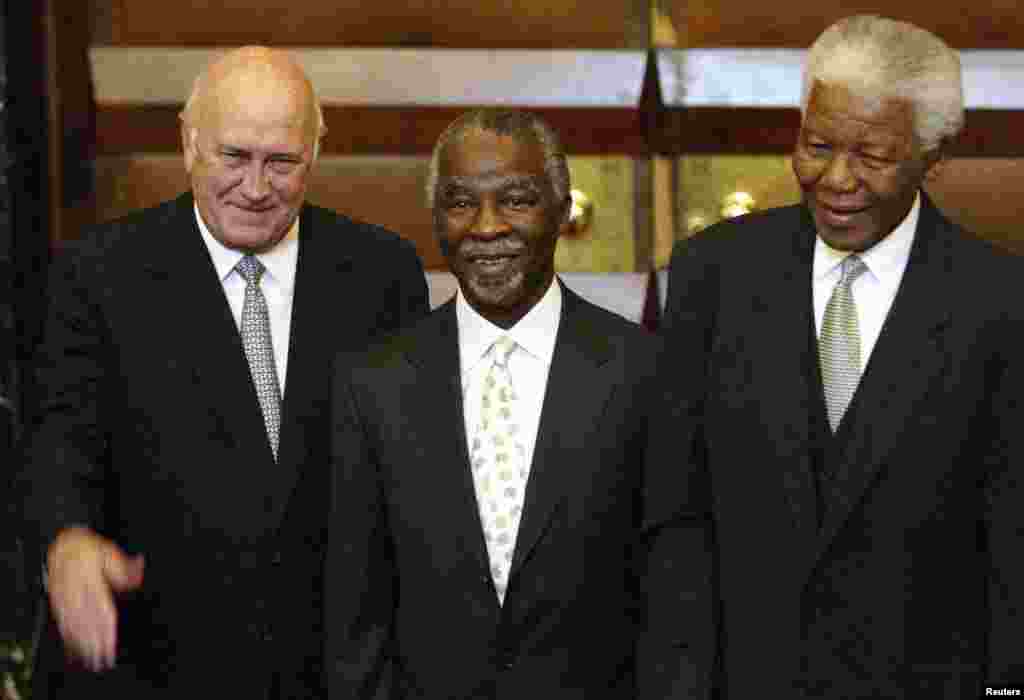 Tous anciens président de l'Afrique du Sud, Thabo Mbeki, le successeur de Mandela (au centre) et FW de Klerk, le prédecesseur de Mandela (à gauche) et Nelson Mandela (à droite) posent pour les photographes au Parlement au Cap. Photo d'archive prise après l'élection de Mbeki en tant que président de l'ANC le 10 mai 2004.