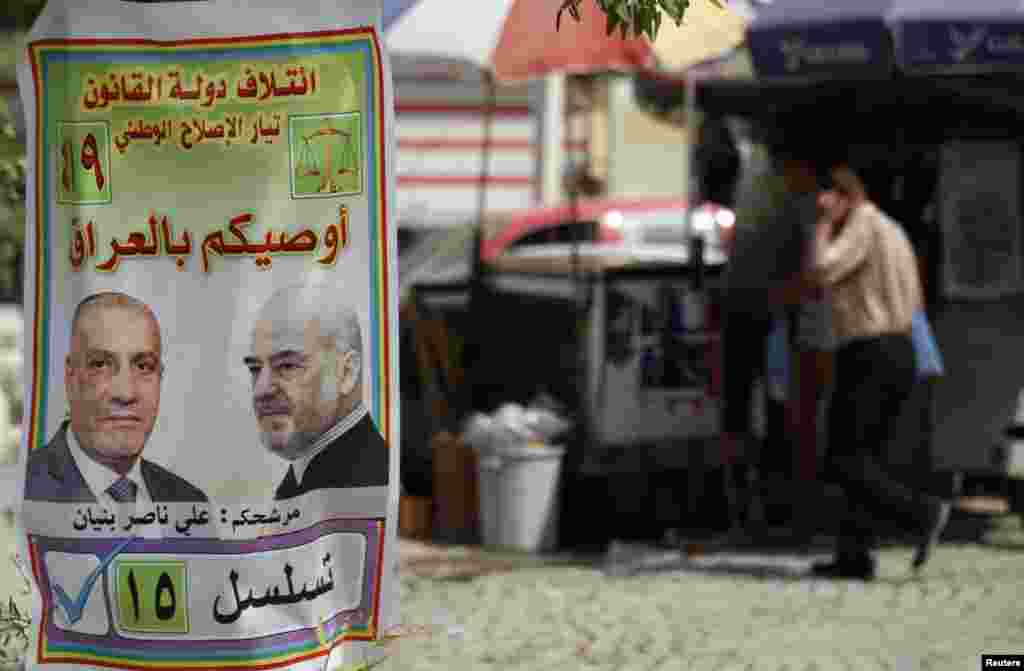 Seorang warga Irak berjalan melewati poster kampanye pemihan tingkat propinsi di Baghdad, 18 April 2013. Irak akan menggelar pemilihan pemeritah daerah pada hari Sabtu.