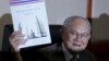 Meechai Ruchupan, head of Thailand's Constitution Drafting Committee, holds up a draft constitution during a news conference at the parliament in Bangkok, Thailand on March 29, 2016. 