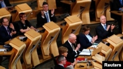 Scottish National Party lawmakers applaud after the vote on a second independence referendum in the Parliament in Holyrood, Edinburgh, March 28, 2017.