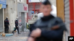 Bomberos salen del edificio donde se escondía el terrorista Abdelhamid Abaaoud en Saint-Denis, en las afueras de París.