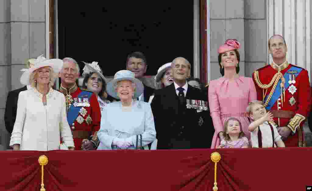 Anggota Keluarga Kerajaan Inggris dari kiri, Camilla, Duchess of Cornwall, Pangeran Charles, Puteri Eugenie, Ratu Elizabeth II, di latar belakang tampak Timothy Laurence, Putri Beatrice, Pangeran Philip, Kate, Duchess of Cambridge, Puteri Charlotte, Pangeran George, dan Pangeran William menyaksikan terbang lintas dengan tampil di balkon Istana Buckingham, setelah menghadiri upacara Trooping the Colour di London, 17 Juni 2017.