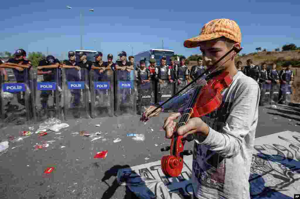 A refugee boy plays a violin as hundreds of migrants camp for a second day as they try to march down a highway towards Turkey’s western border with Greece and Bulgaria, near Edirne, Turkey.