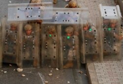 Lebanese soldiers hide from stones behind their protective shields as they clash with supporters of Prime Minister-designate Saad Hariri who stepped down in Beirut, Lebanon, July 15, 2021.