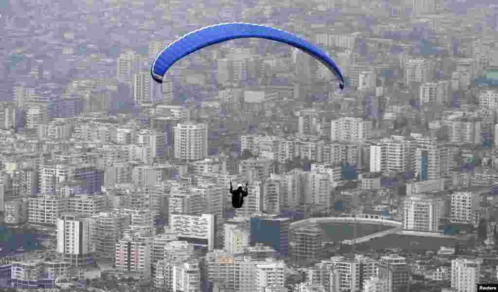 Seorang paraglider terbang di atas kota Vlore, Albania dalam lomba paragliding Balkan, sekitar 150 kilometer dari ibukota Tirana.