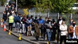 People line up outside a mobile vaccination center, amid the outbreak of the coronavirus disease (COVID-19) in Bolton, Britain, May 16, 2021. 