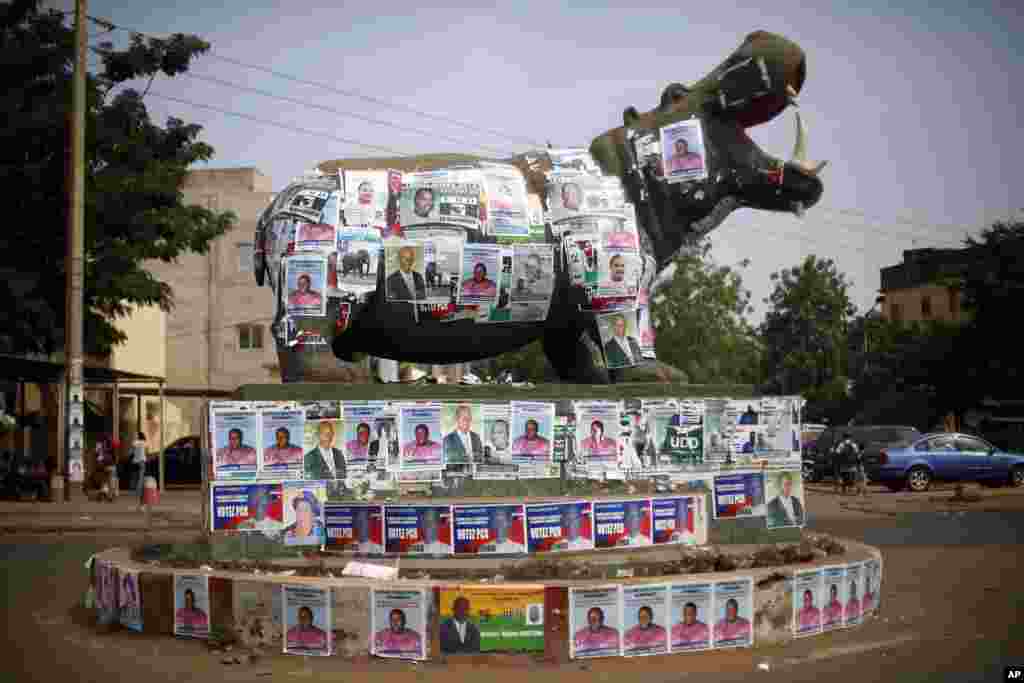 A statue of a hippopotamus is covered with election posters at a traffic circle in Bamako, Mali, Nov. 19, 2013.