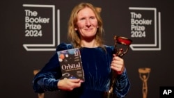 Samantha Harvey poses with the trophy and her book "Orbital" after winning the Booker Prize award 2024, in London, Nov. 12, 2024. 