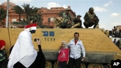 Photo de famille devant un tank sur la place Tahrir, au Caire