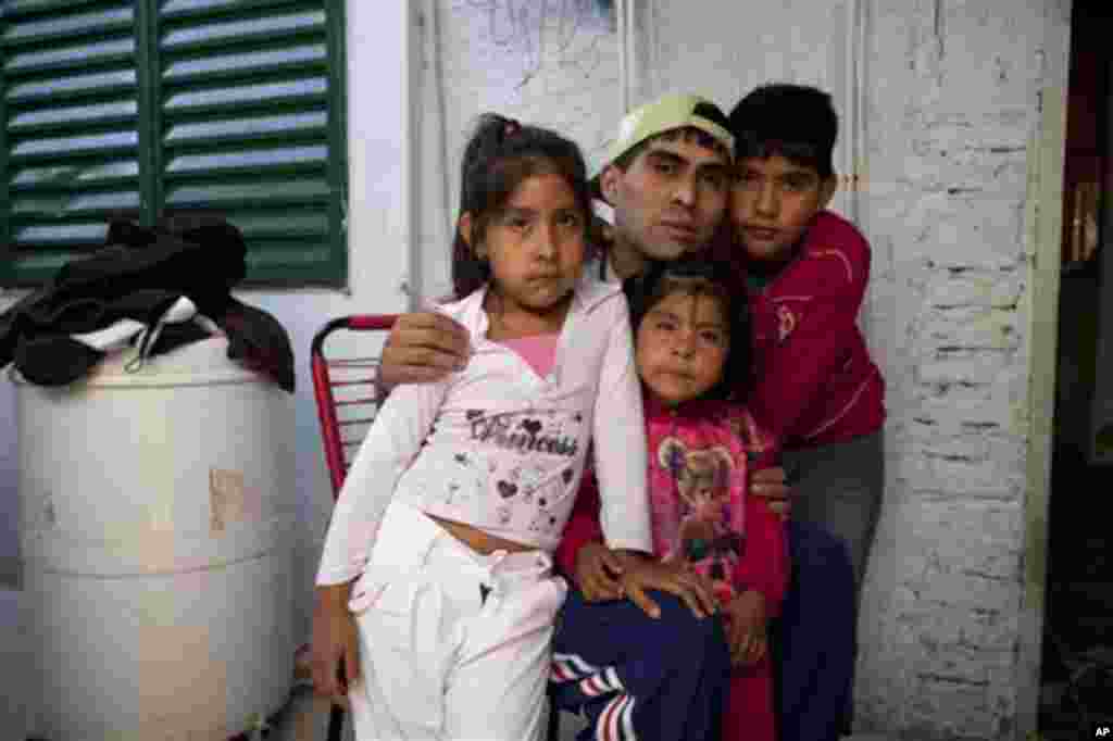 Cristian Marcelo Reynoso, center, poses inside his home with his children, Milagro, 5, left, Oriana, 3, bottom, and Nahuel, 10, right, in their home in the Villa 21-24 slum in Buenos Aires, Argentina, March 14, 2013. At Villa 21-24, a slum so dangerous that most outsiders wouldn't dare go in, Jorge Mario Bergoglio often showed up unannounced to share laughs and sips of mate, the traditional Argentina herbal tea.