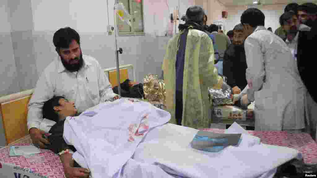 Un homme réconforte son fils, qui a été blessé lors d'une attaque par des hommes armés talibans sur l'école publique de l'Armée, à l'hôpital Lady Reading à Peshawar, au Pakistan, le 16 décembre 2014.