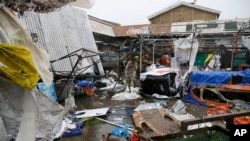 Residents walk along destroyed stalls at a public market after Typhoon Mangkhut barreled across Tuguegrao city in Cagayan province, northeastern Philippines, Sept. 15, 2018.