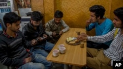 Kashmiri students browse the internet on their mobile phones as they sits inside a restaurant in Srinagar, Indian controlled Kashmir, April 26, 2017. On Wednesday, authorities ordered internet service providers to block 16 social media sites, including Facebook and Twitter, and popular online chat applications for one month "in the interest of maintenance of public order." 