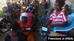 Deslocados, vítimas, da violência armada em Cabo Delgado aguardam na rua com as senhas para adquirir os seus produtos através da ajuda do PMA, em Pemba.
