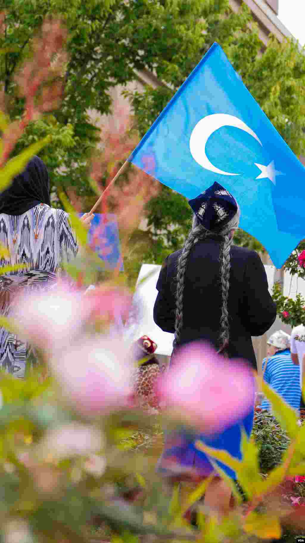 Uyg'urlar Sharqiy Turkiston bayroqlarini ko'tarib, Xitoy elchixonasi qarshisida bu davlatning uyg'urlarga qarshi siyosatini qoralab, namoyish qilmoqda, Vashington, 3-avgust, 2014-yil. Odil Ruzaliev surati