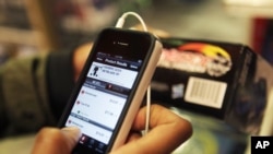 FILE - A shopper uses his smartphone to compare prices in New York, Nov. 28, 2011. A startup in California allows individuals to broadcast their personal phone screen to viewers, who can follow along and comment.