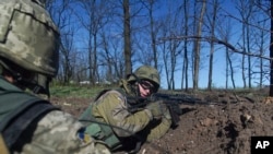 FILE - Ukrainian military servicemen control their position during a cease-fire outside Avdiivka, eastern Ukraine, April 16, 2016. 