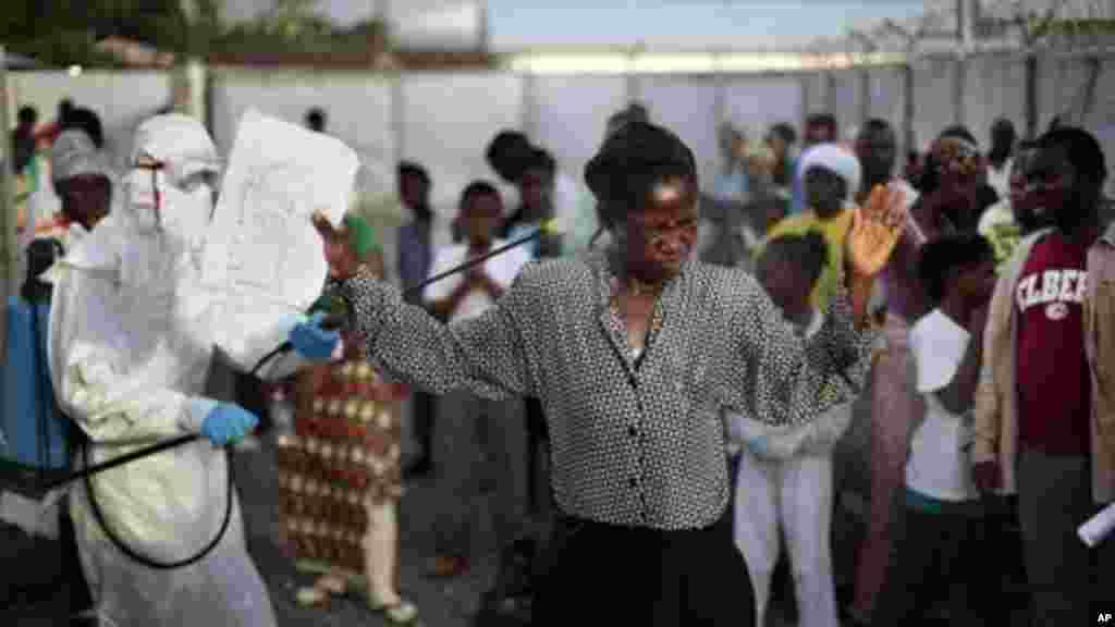 Cette femme, déclarée guérie d’Ebola, rend grâce à Dieu après avoir été libérée de la clinique de traitement d’Ebola à Monrovia, Liberia. Elle devra cependant être acceptée à nouveau dans sa communauté. Le 30 septembre 2014. (AP Photo/Jerome Delay)