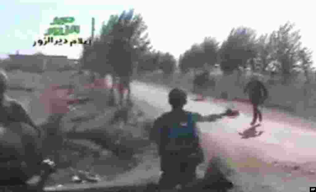 A still from amateur video provided by Ugarit News, shows Syrian rebels during a raid on Hatla, Syria, June 12, 2013.