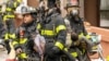 Des pompiers secourent les victimes de l'incendie qui s'est déclaré dans un immeuble du 19 dans le Bronx, à New York, aux États-Unis, dimanche 9 janvier 2022 au matin. (Photo : Theodore Parisienne/pour New York Daily News)