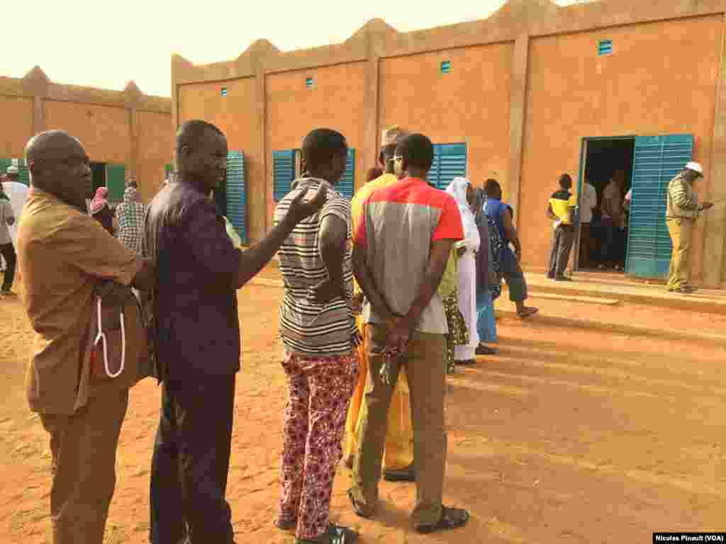 File d'attente devant le bureau de vote de l'école Yantala Haut à Niamey, qui a ouvert une heure en retard, Niamey, 21 février 2016 (VOA/Nicolas Pinault)