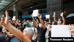 Manifestantes en Hong Kong levantan papeles en blanco como alegoría a los lemas prohibidos por la nueva ley de seguridad nacional impuesta por China.