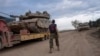 FILE - Seorang tentara Israel memindahkan tank ke truk pengangkut di daerah dekat perbatasan Israel-Lebanon, di Israel utara, 4 Desember 2024.