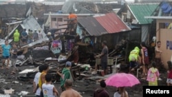 Residents stand among their damaged houses after Typhoon Kammuri hit Legazpi City, Albay, Philippines, December 2, 2019. REUTERS/Nino Luces NO RESALES. NO ARCHIVES