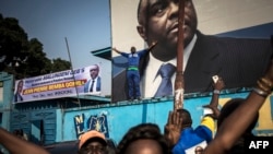 Les partisans de Jean-Pierre Bemba devant la photo de leur leader au siège du Mouvement de libération du Congo (MLC) à Kinshasa le 8 juin 2018 .