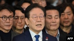 South Korea's main opposition Democratic Party leader Lee Jae-myung (C) speaks to the media at the National Assembly in Seoul on December 4, 2024, after South Korea President Yoon Suk Yeol declared martial law.