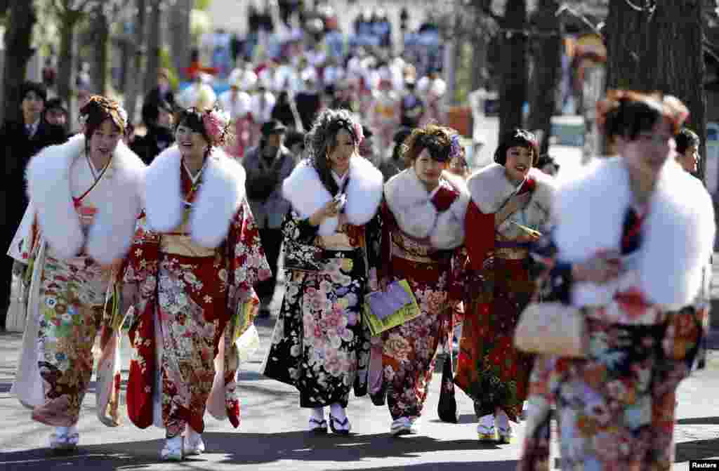 Japanese women in kimonos attend a ceremony celebrating Coming of Age Day at an amusement park in Tokyo.