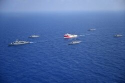 FILE - A handout photograph released by the Turkish Defense Ministry Aug. 12, 2020, shows Turkish seismic research vessel Oruc Reis, center, as it is escorted by Turkish Naval ships in the Mediterranean Sea, off Antalya, Aug. 10, 2020.