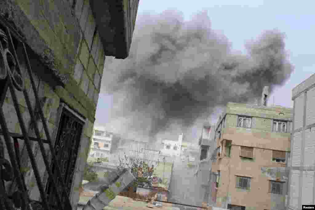 Smoke rises from what activists said were explosive barrels thrown from helicopters on Daria outside Damascus, Jan. 12, 2014.