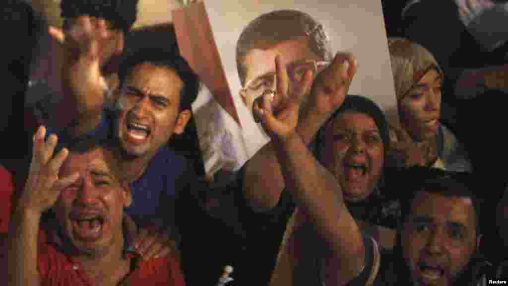 Morsi supporters react after the Egyptian army's statement was read out on state TV, at the Raba El-Adwyia mosque square in Cairo, July 3, 2013.