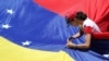 A supporter of Venezuelan opposition leader Juan Guaido, who many nations have recognized as the country's rightful interim ruler, fixes a flag during a rally against Venezuelan President Nicolas Maduro's government in Caracas, Venezuela, April 6, 2019…