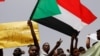 Les manifestants agitent des drapeaux soudanais, tiennent des banderoles et scandent des slogans lors d'une manifestation devant le ministère de la Défense à Khartoum, au Soudan, le 18 avril 2019. 