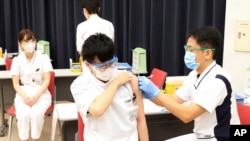 FILE - Medical workers receive doses of Pfizer's COVID-19 vaccine at the Tokyo Metropolitan Cancer and Infectious Diseases Center Komagome Hospital in Tokyo, March 5, 2021.