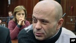 Politkovskaya's daughter Vera, background, looks at former police officer Dmitry Pavlyuchenko, right, prior to the judge's verdict, at the Moscow City Court, Russia, December 14, 2012