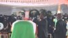 Le président ivoirien Alassane Ouattara (C) place une décoration sur le cercueil de feu le Premier ministre ivoirien Hamed Bakayoko lors de sa cérémonie d'hommage officielle le 17 mars 2021.