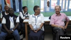 Le président des Seychelles James Michel, à droite, discute avec l'avocat Alexia Antao dans un centre de vote pendant les élections présidentielles à Victoria, Seychelles, le 3 décembre 2015. Michel a remporté un troisième mandat le samedi 19 décembre 2015.