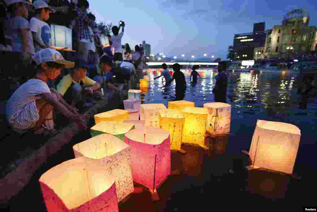 Warga melarung lentera kertas di Sungai Motoyasu yang menghadap ke Kubah Bom Atom untuk mengenang para korban serangan di Hiroshima (6/8). (Kyodo)