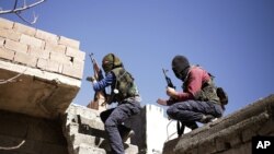Militan dari Partai Pekerja Kurdi (PKK) sedang berlindung di balik tembok saat menyerang pasukan keamanan Turki di Nusaydin, Turki (1/3).