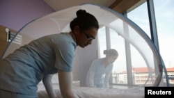 Nurses set up a mosquito tent over a hospital bed, as part of a precautionary protocol for patients who are infected by Zika at Farrer Park Hospital in Singapore Sept. 2, 2016.