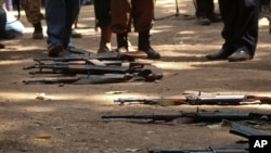 Des armes ayant appartenu à des enfants soldats gisent au sol lors d'une cérémonie de libération, où ils ont déposé leurs armes et échangé leurs uniformes pour revenir à une «vie normale», à Yambio, au Soudan du Sud, le 7 février 2018.