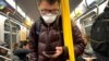 Arhiva - Čovek nosi masku dok se vozi metroom u Njujorku, 12. mart 2020.
