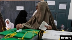 A woman casts her ballot at a polling station in Peshawar May 11, 2013.