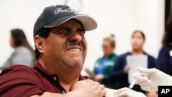 César González reacciona al recibir una vacuna contra la influenza en Eastfield College, Mesquite, Texas, el jueves 23 de enero de 2020. 
