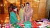 شممامہ ارباب (ائیں) خواتین کے تیار کردہ ملبوسات دیکھ رہی ہیں۔